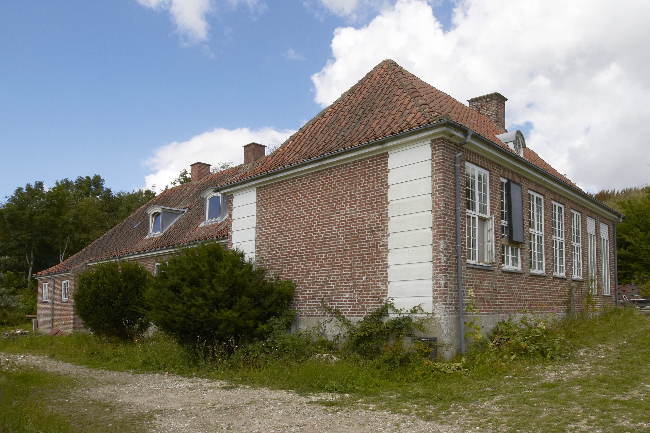 Rødstenshus med tegltag i landlige omgivelser