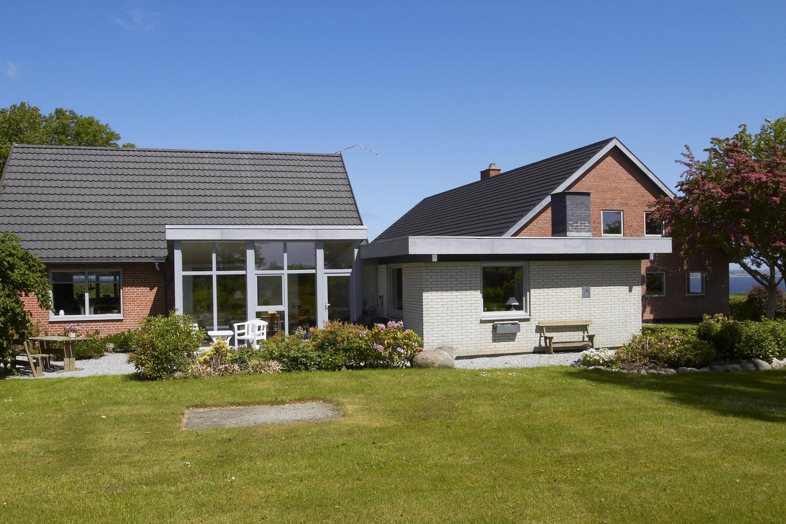 Moderne murstenshus med stor have og terrasse