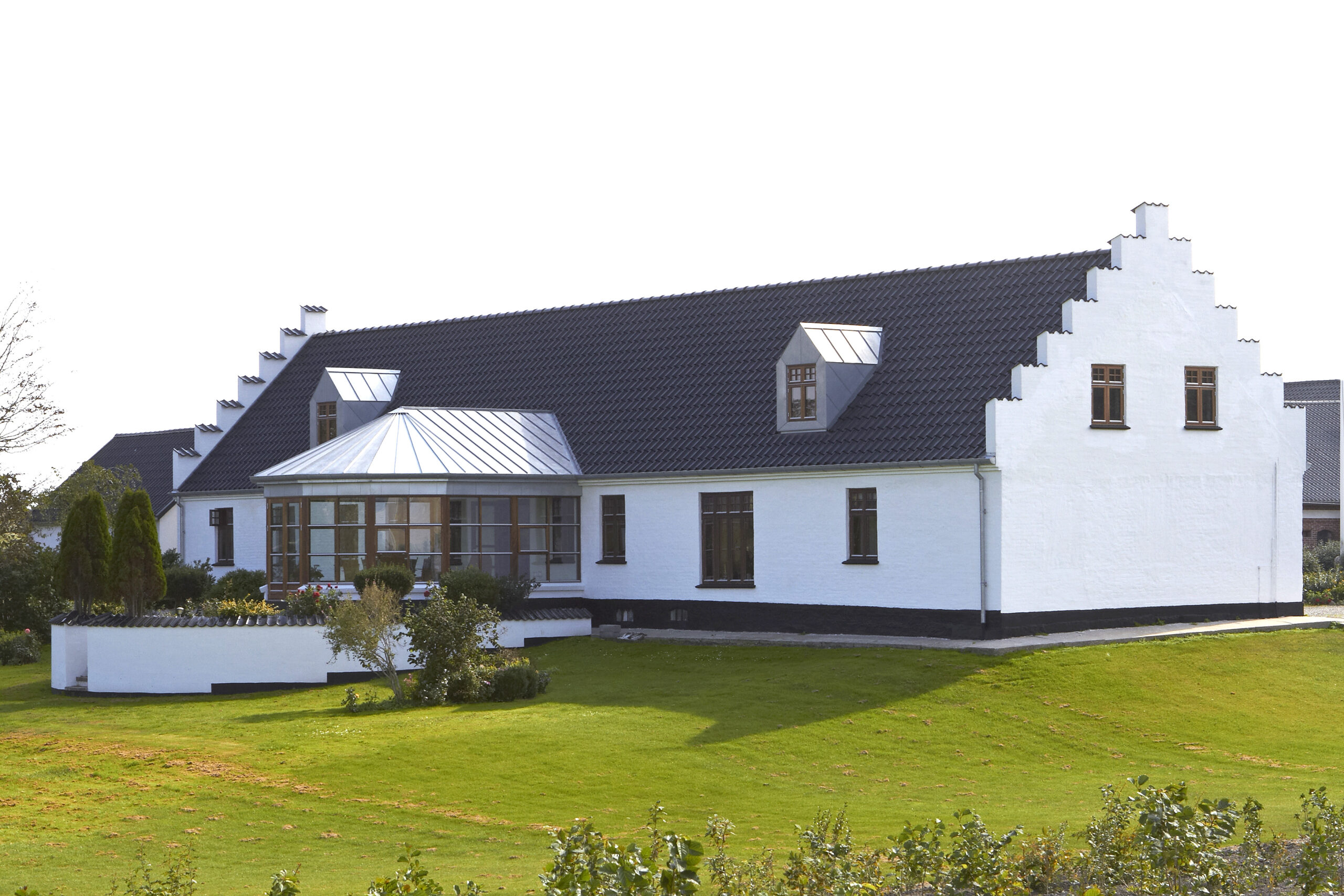 Hvid villa med trappegavle og sort tegltag