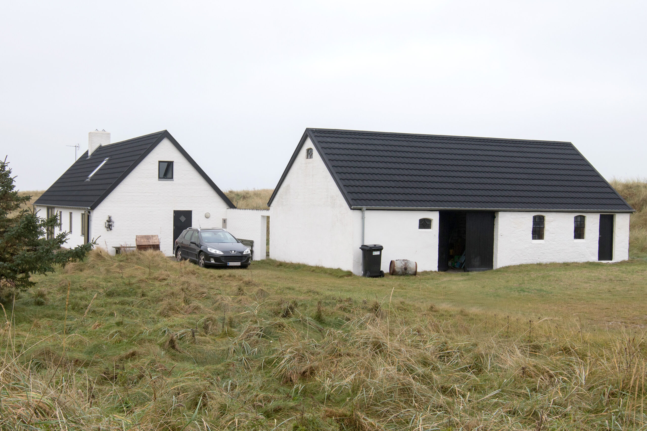 Hvidt hus og udhus i klitlandskab