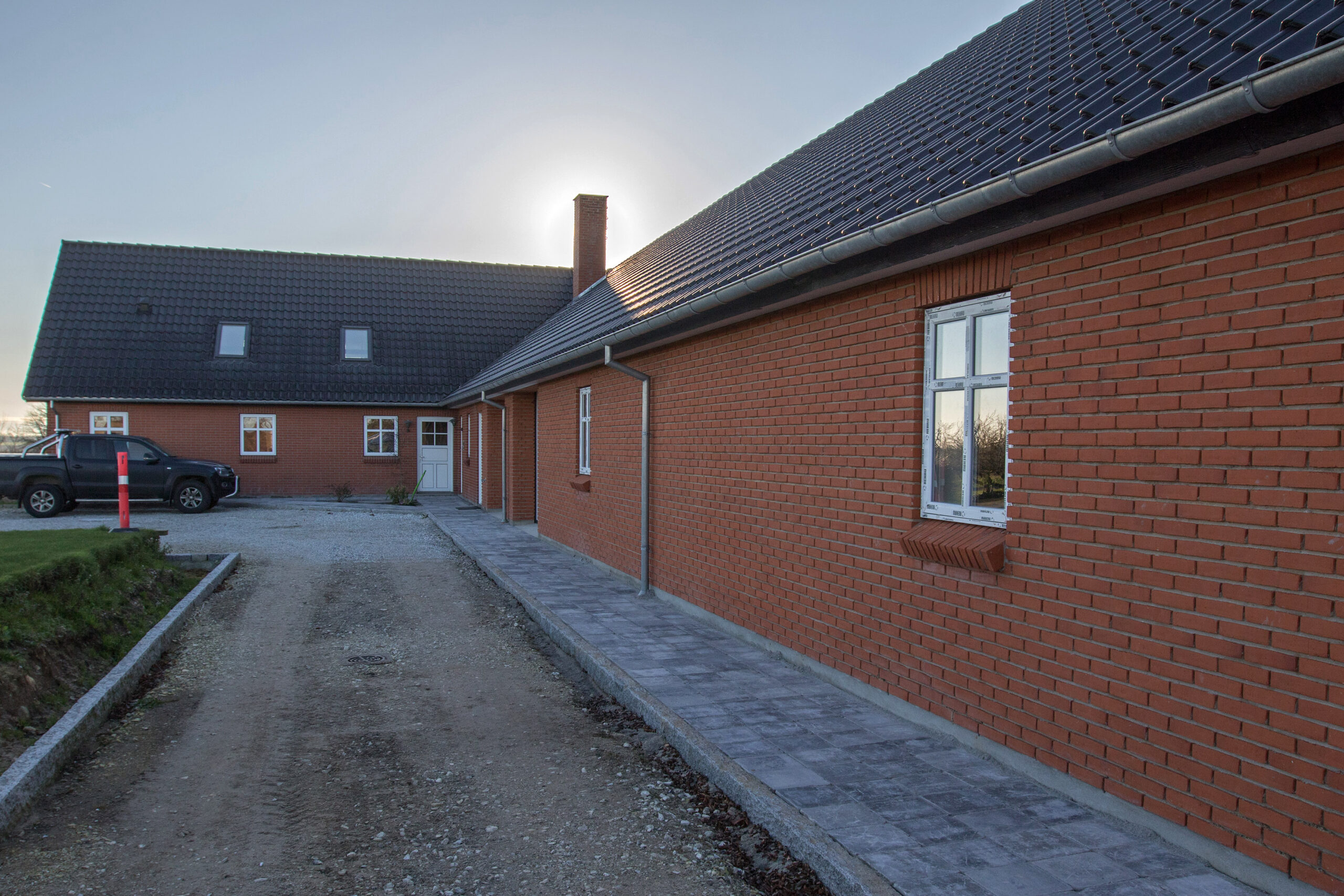 Rødstenshus med tegltag og grusindkørsel