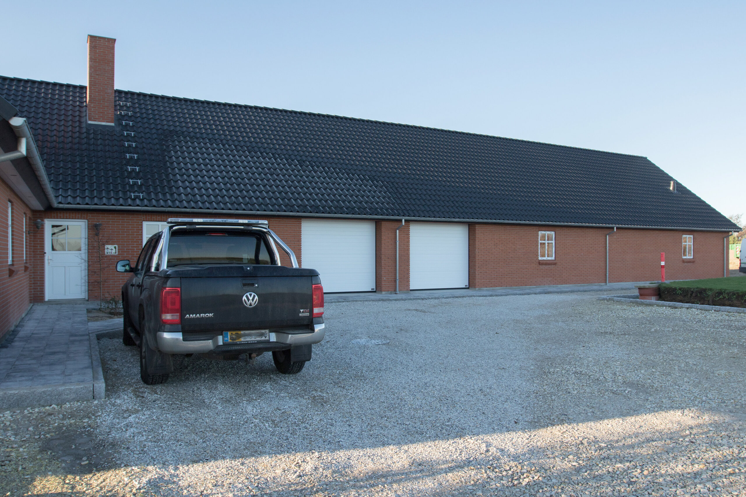 Sort pickup foran murstenshus med dobbeltgarage