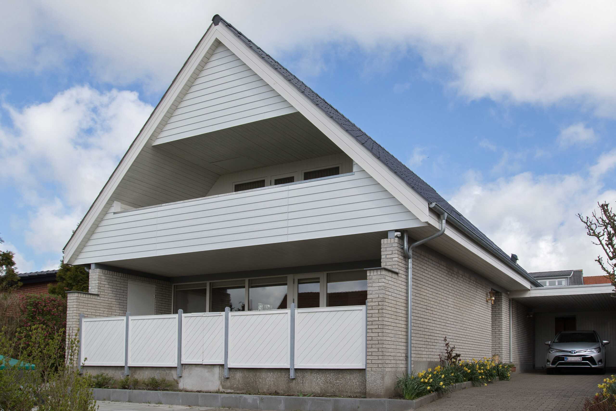 Moderne hus med hvid facade og saddeltag