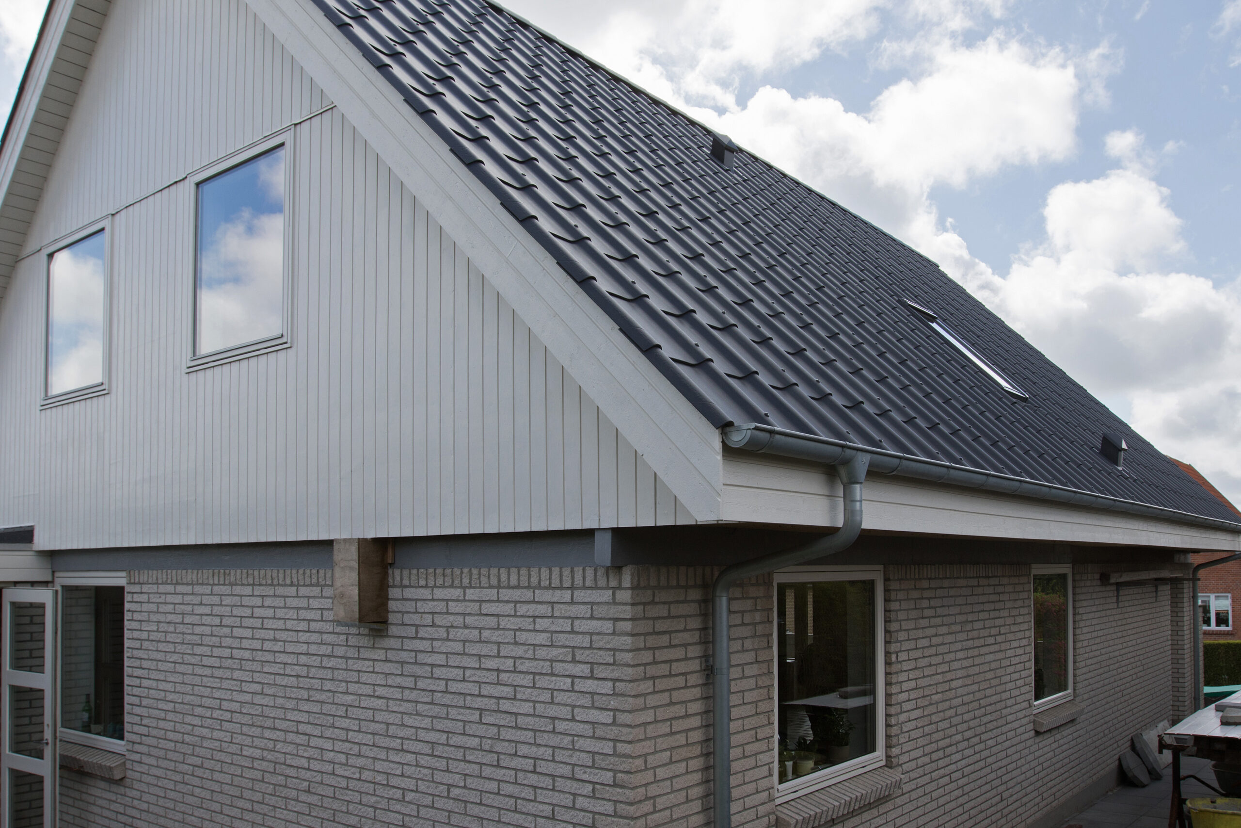 Moderne hus med gråt tegltag og hvid gavl