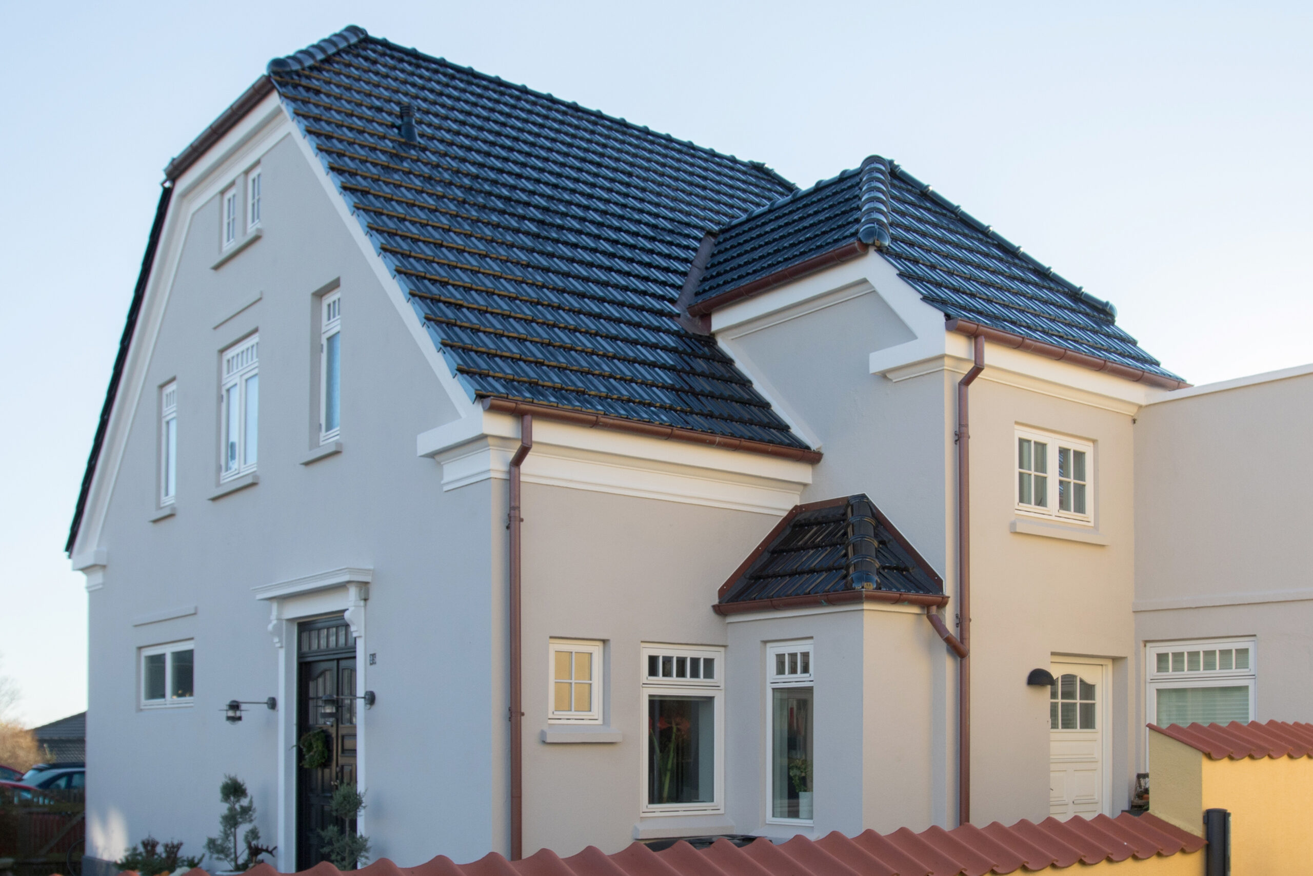 Moderne hus med grå facade og sort tegltag