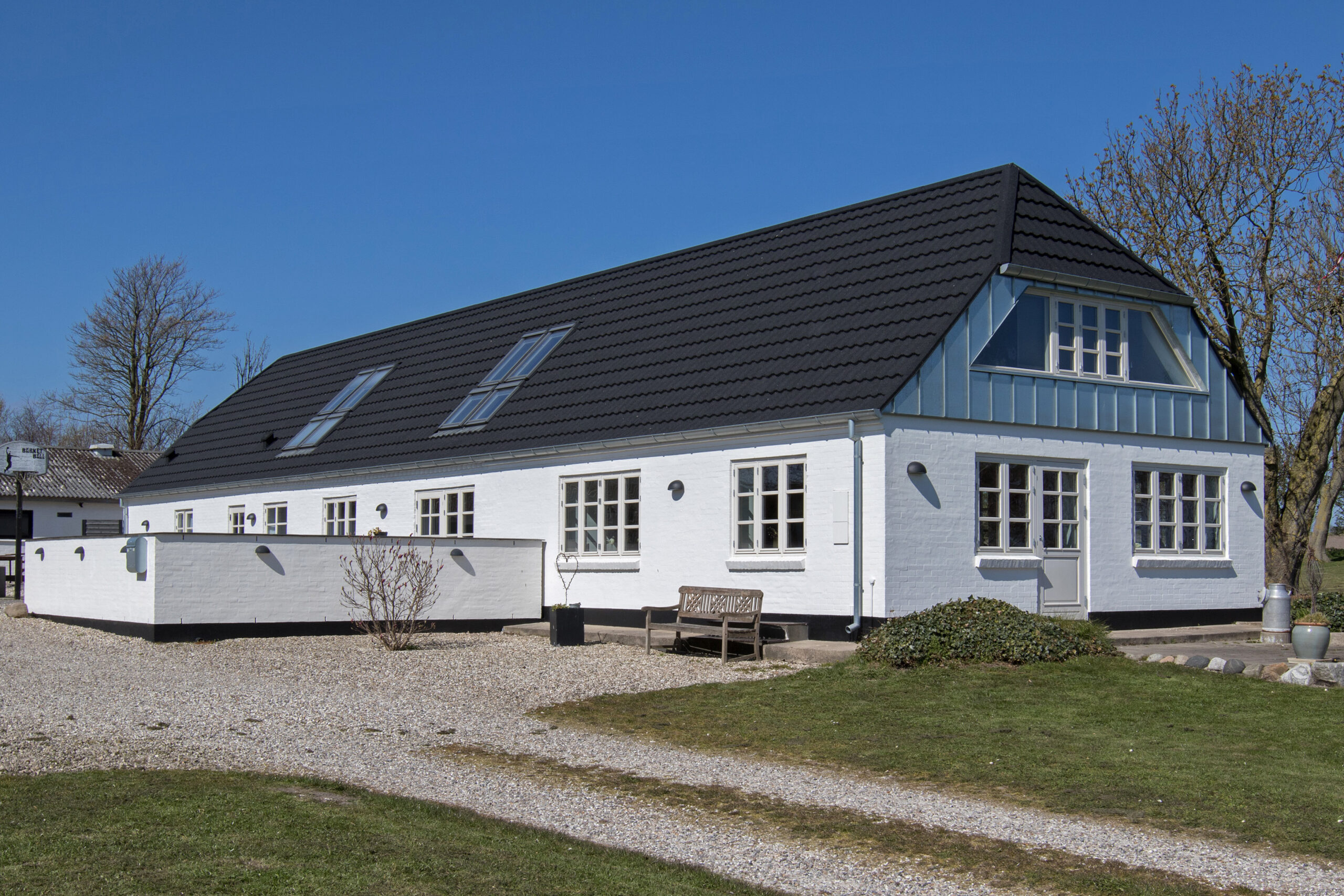 Hvidt murstenshus med sort tag og kvist