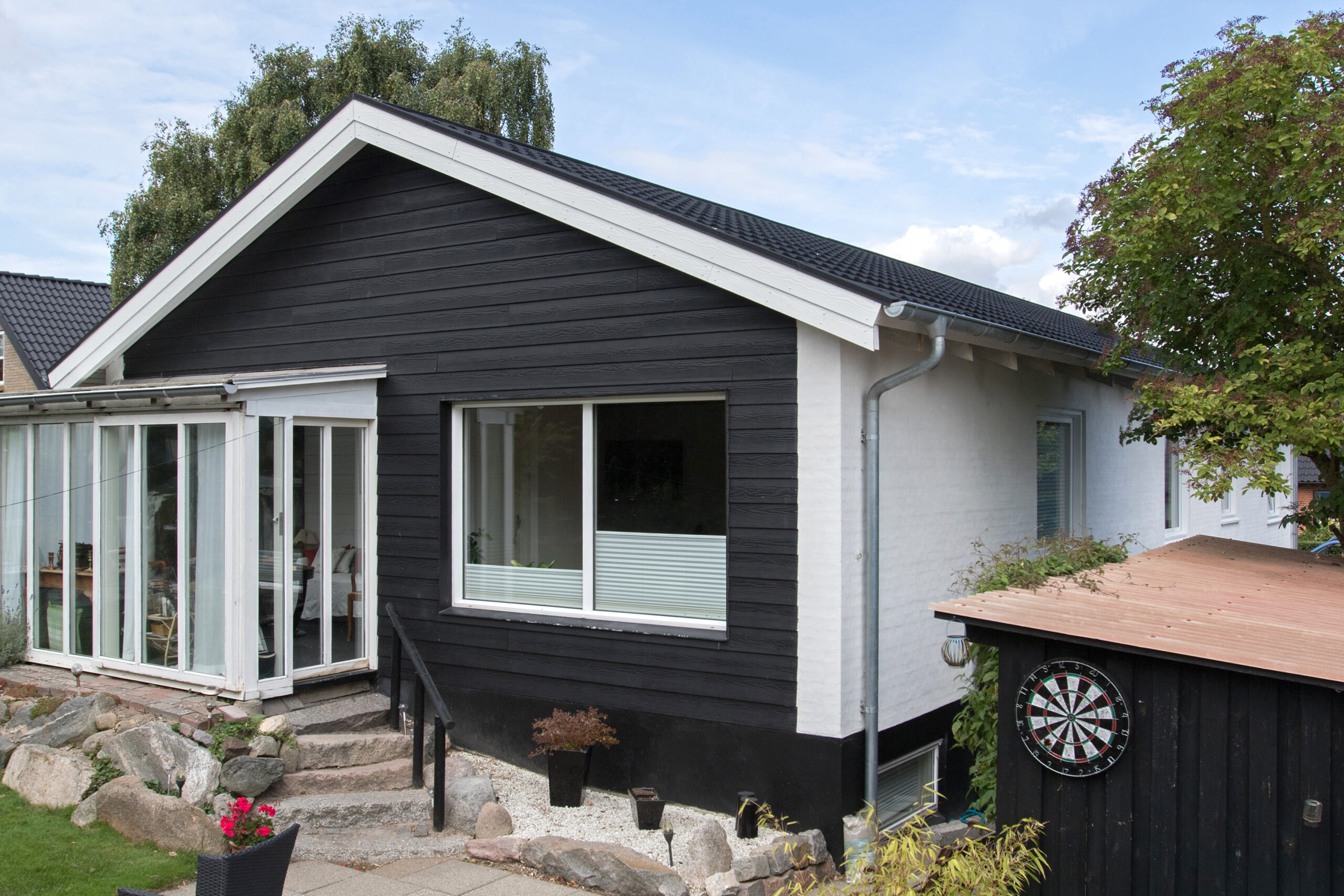 Moderne hus med sort træfacade og terrasse