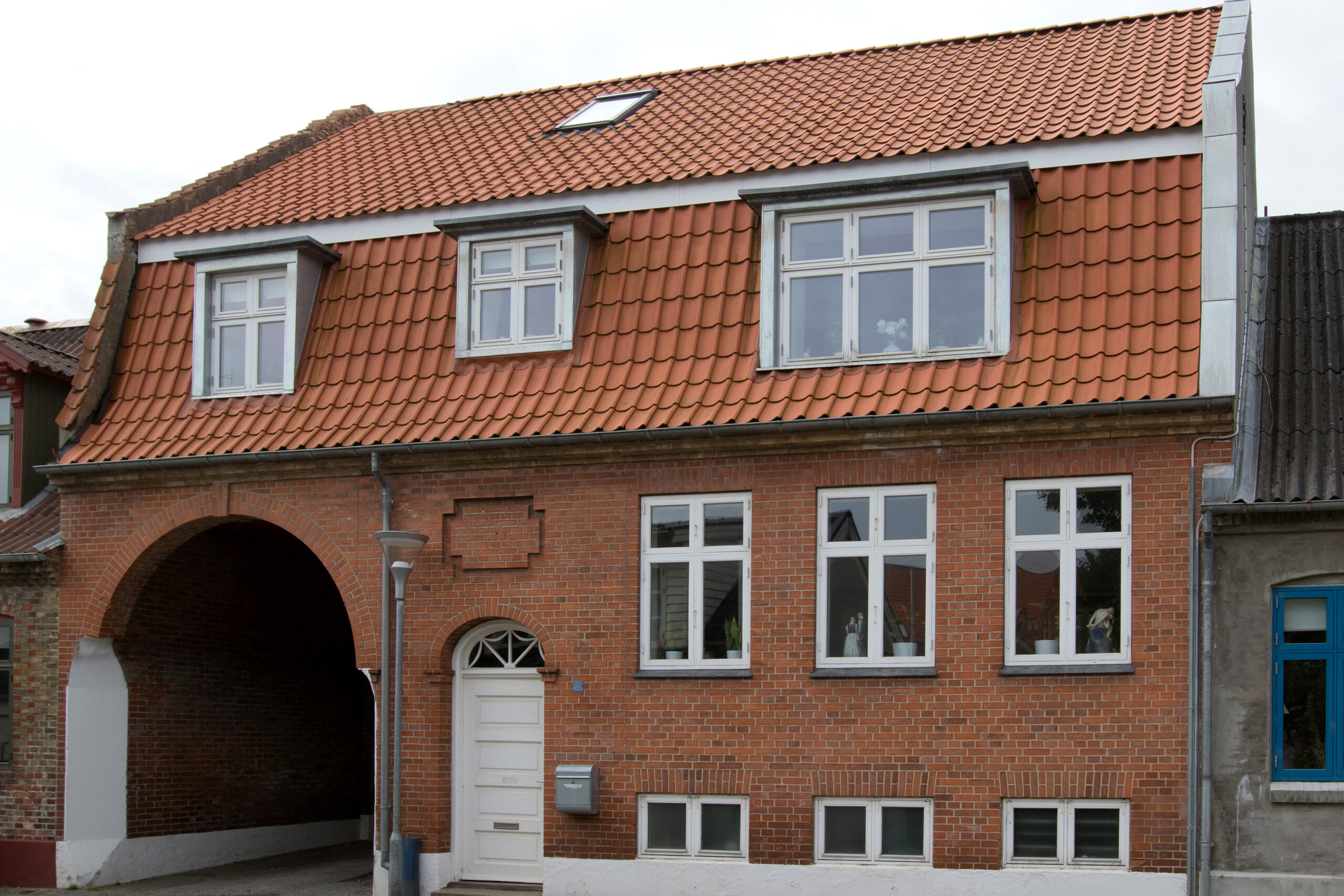 Rødstenshus med tegltag og kviste