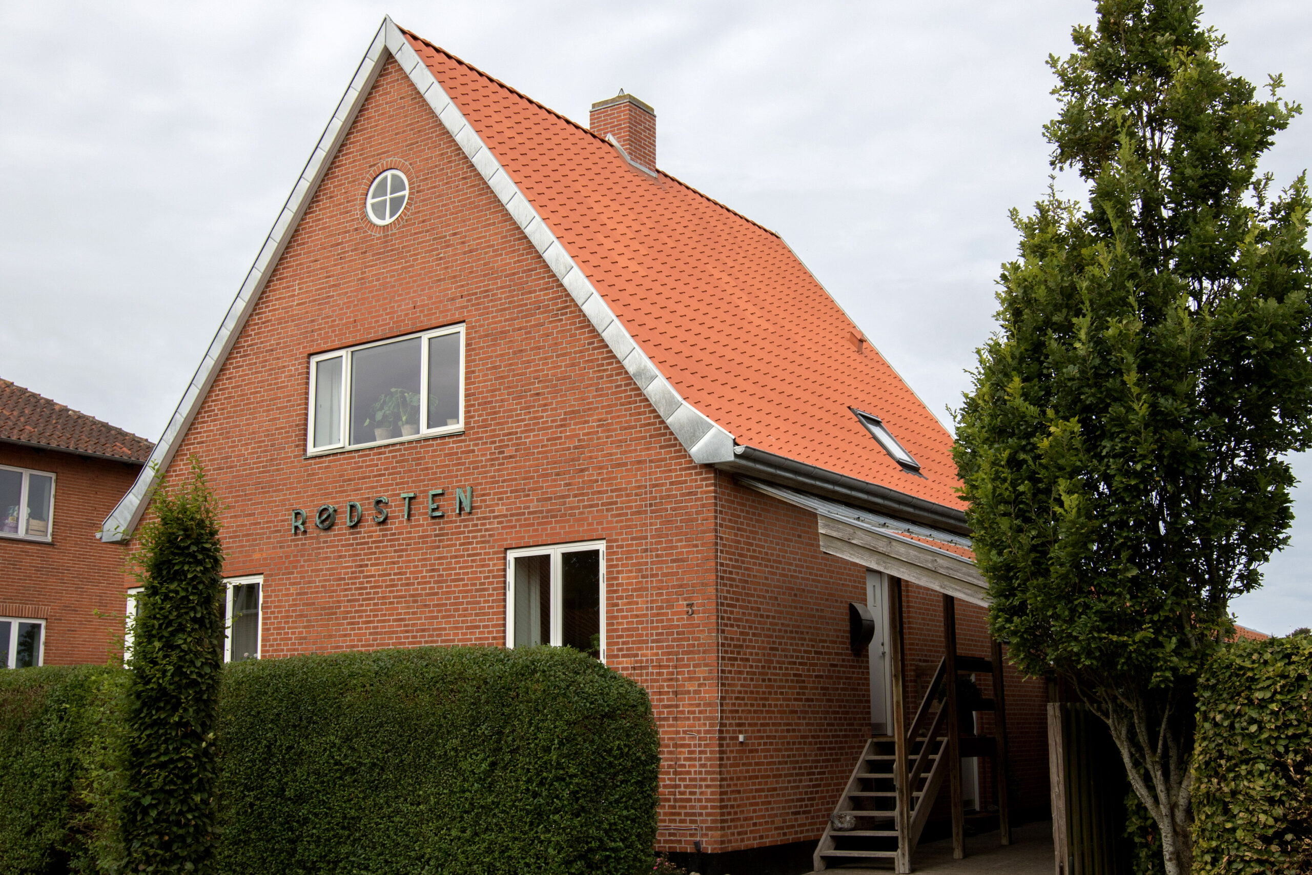 Rødstenshus med orange tegltag og facade