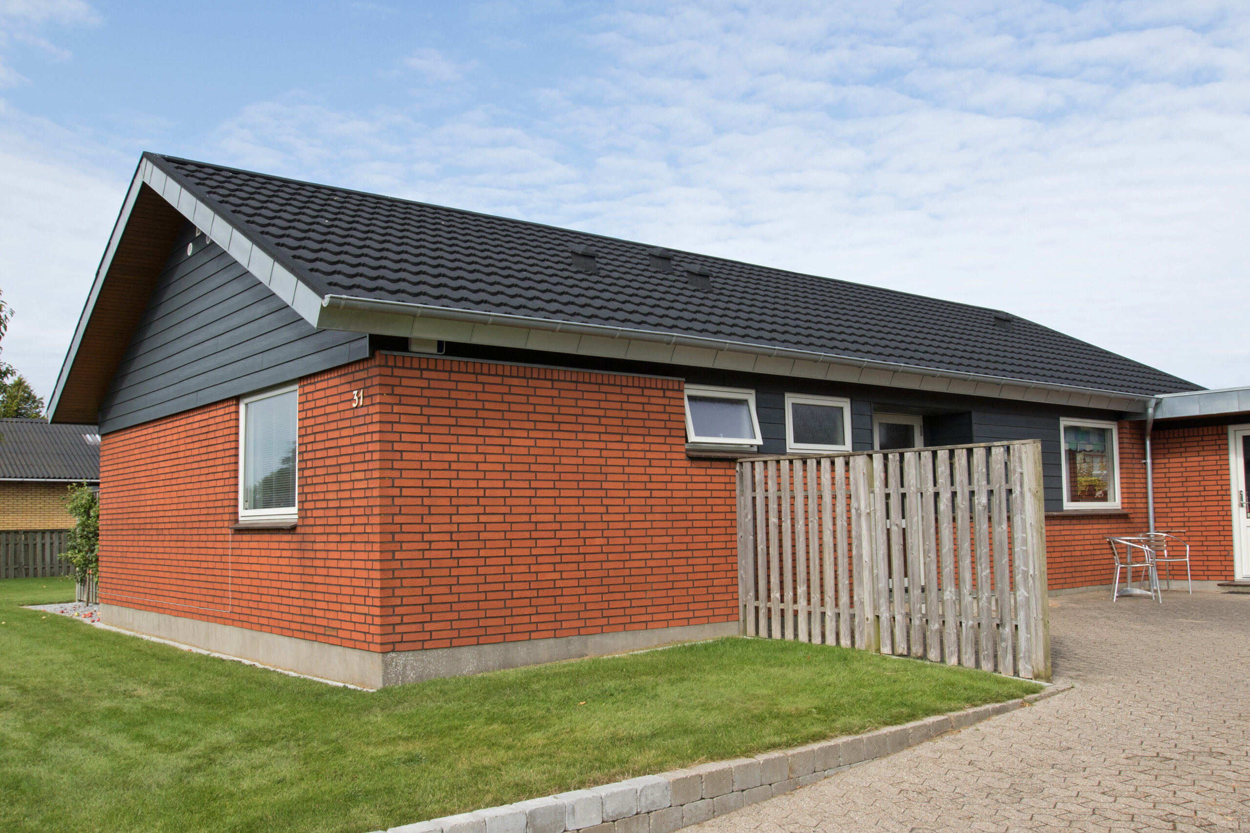 Moderne etplans murstenshus med sort tag