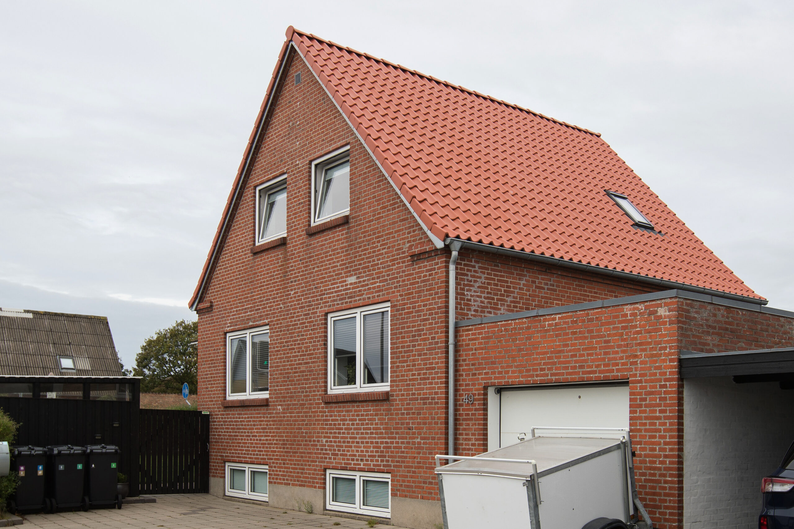 Rødstenshus med rødt tegltag og garage
