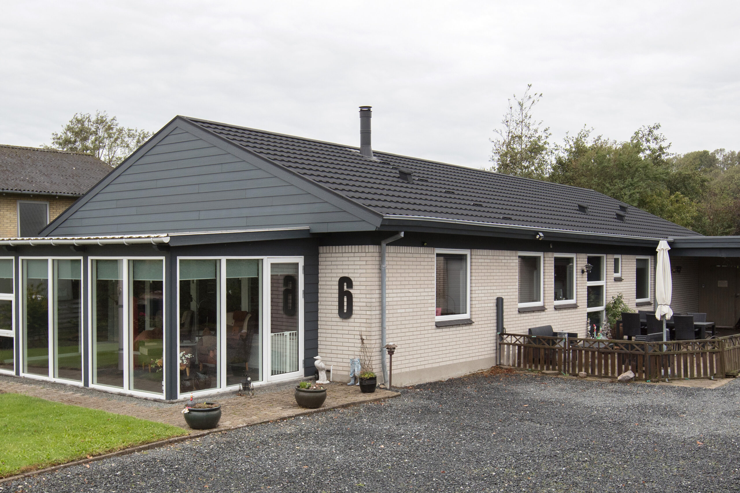 Moderne murstenshus med sort tag og terrasse