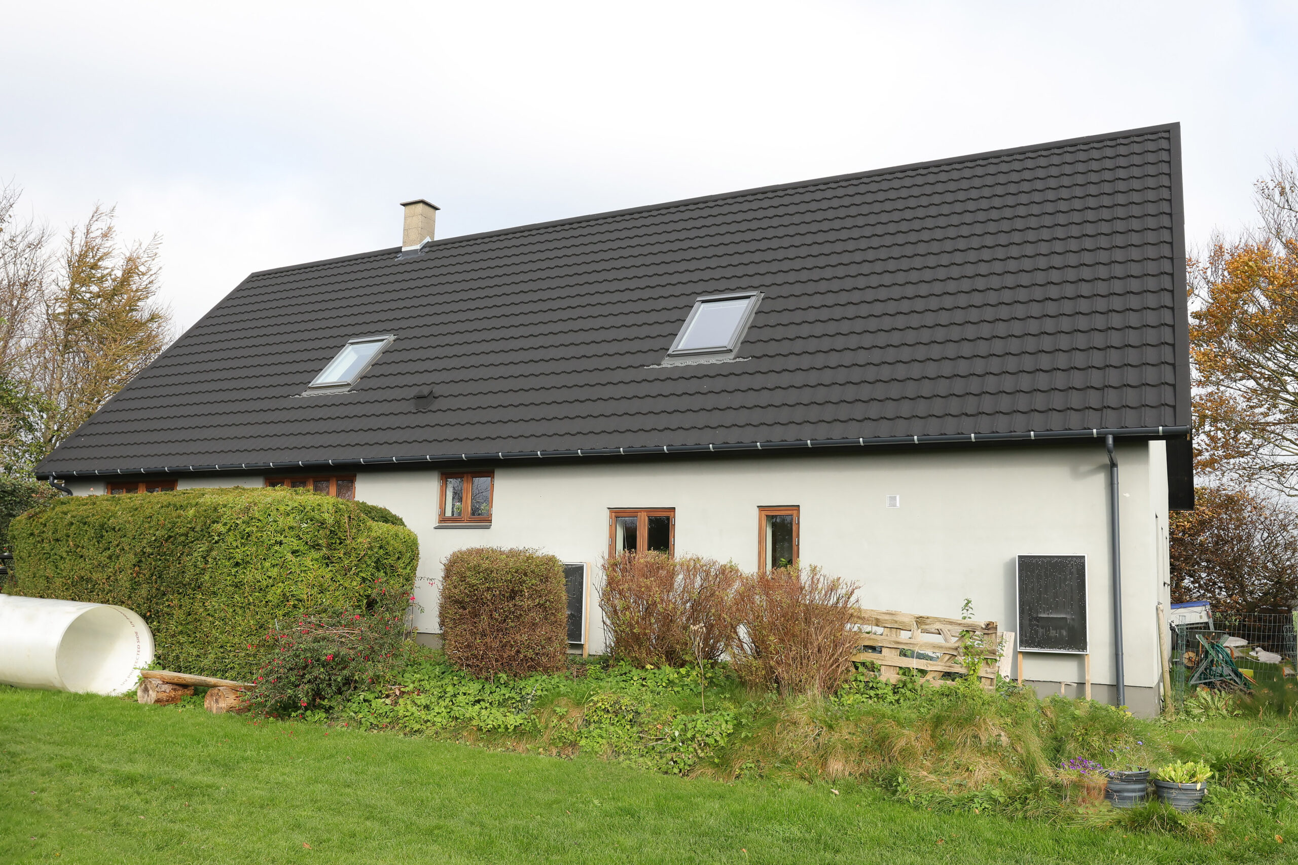 Hus med sort tegltag og ovenlysvinduer