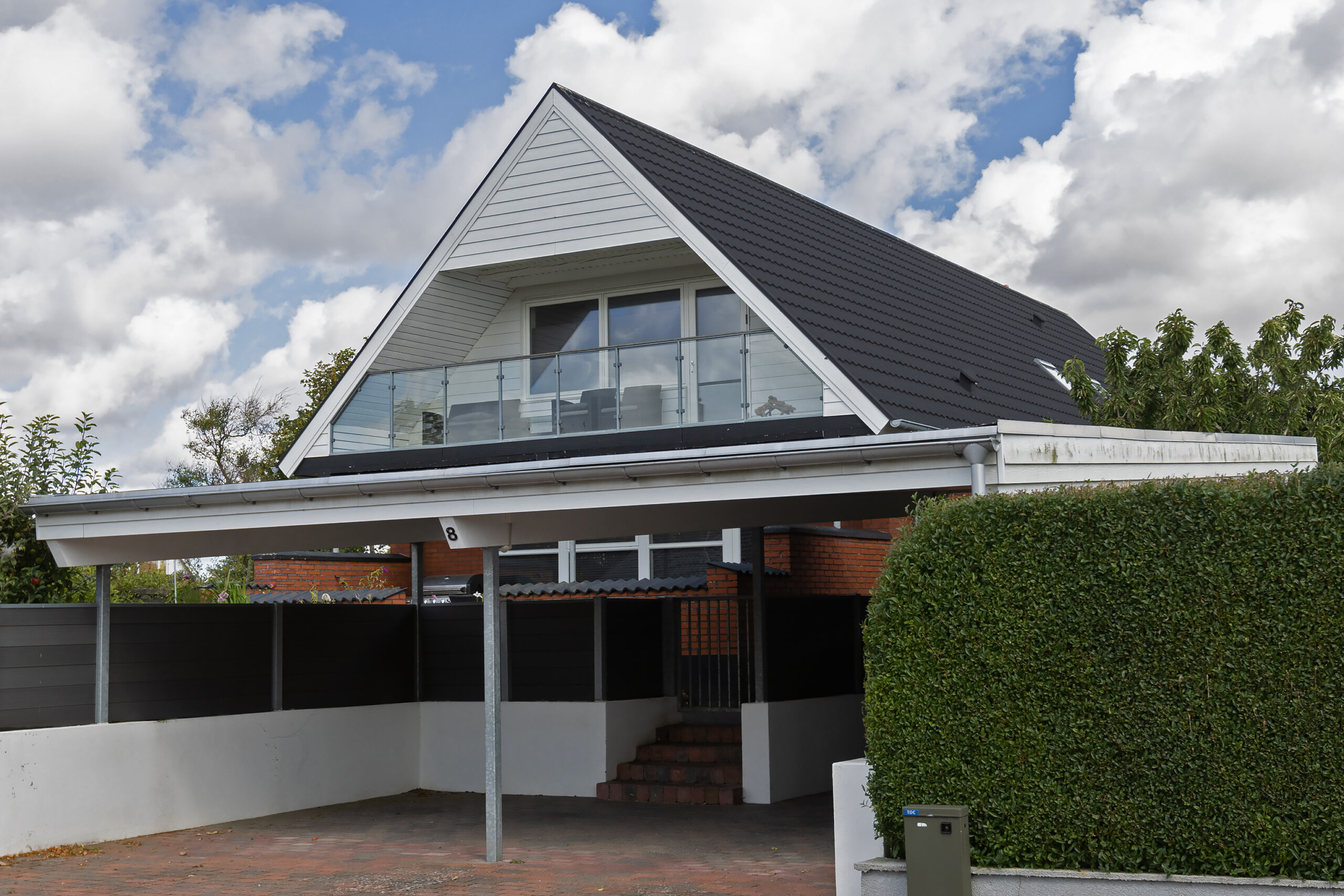 Moderne hvid villa med glasaltan og carport
