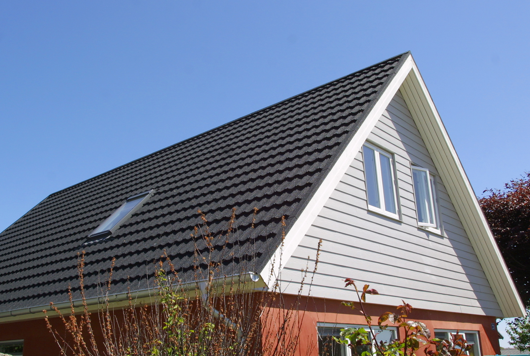Moderne hus med sort tegltag og ovenlysvindue
