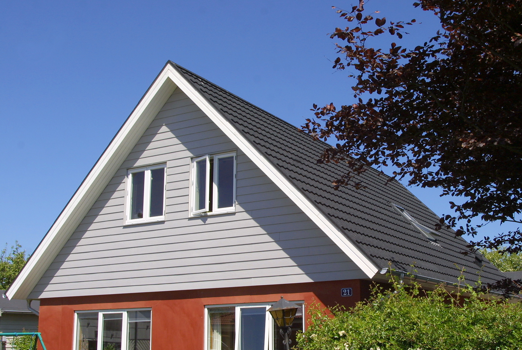 Moderne hus med saddeltag og blå himmel
