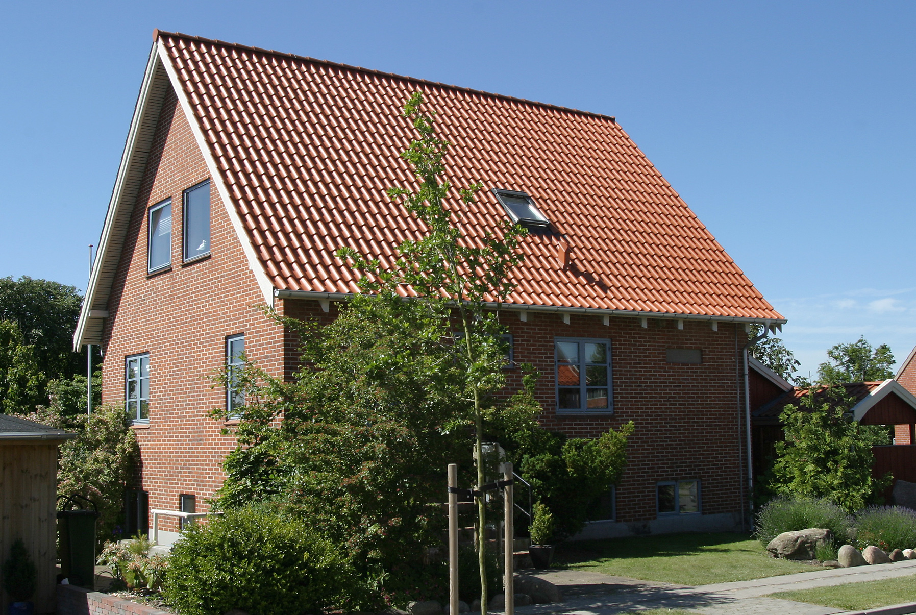Rødstensvilla med tegltag og have