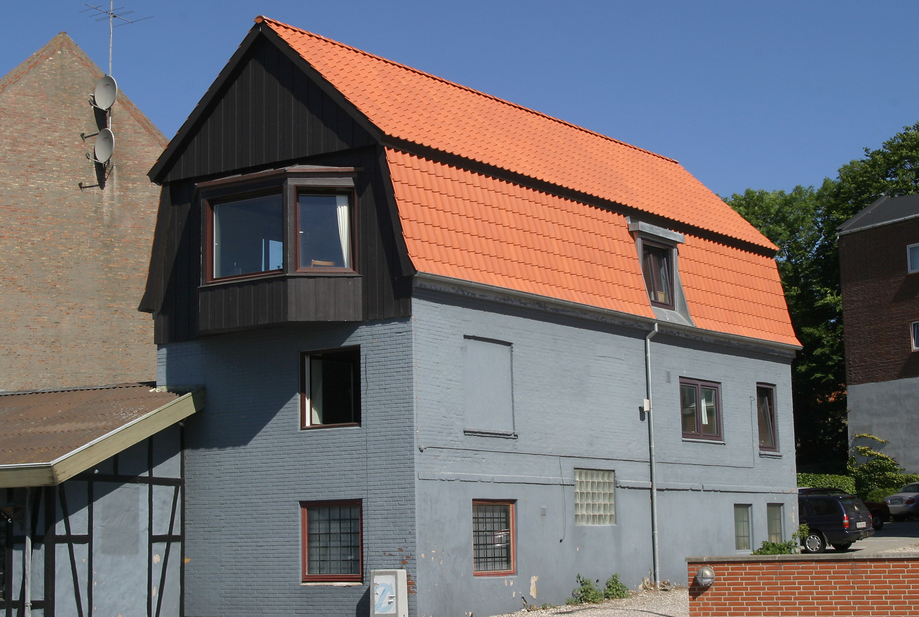 Hus med orange tegltag og mørk facade