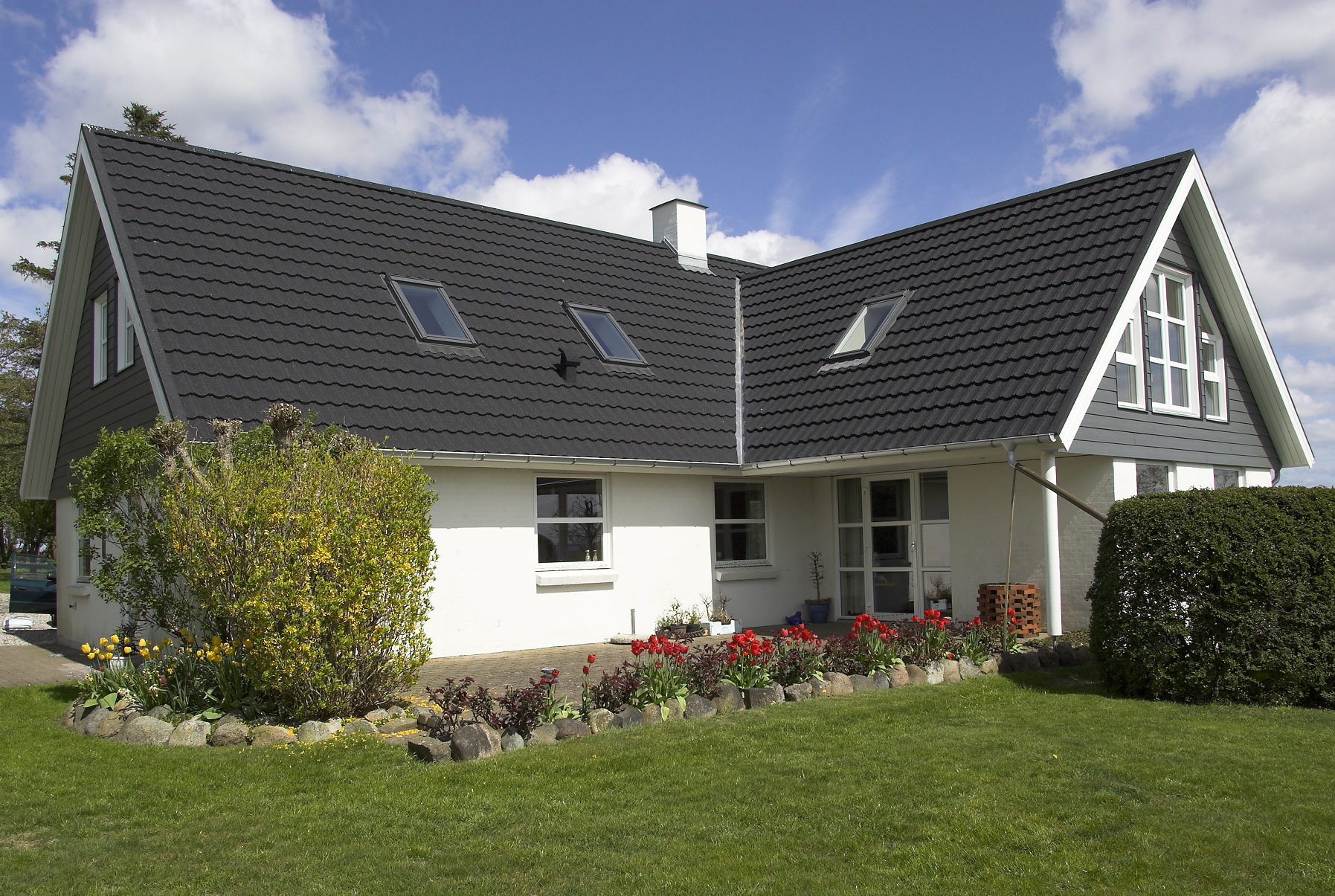 Moderne hus med mørkt tegltag og have