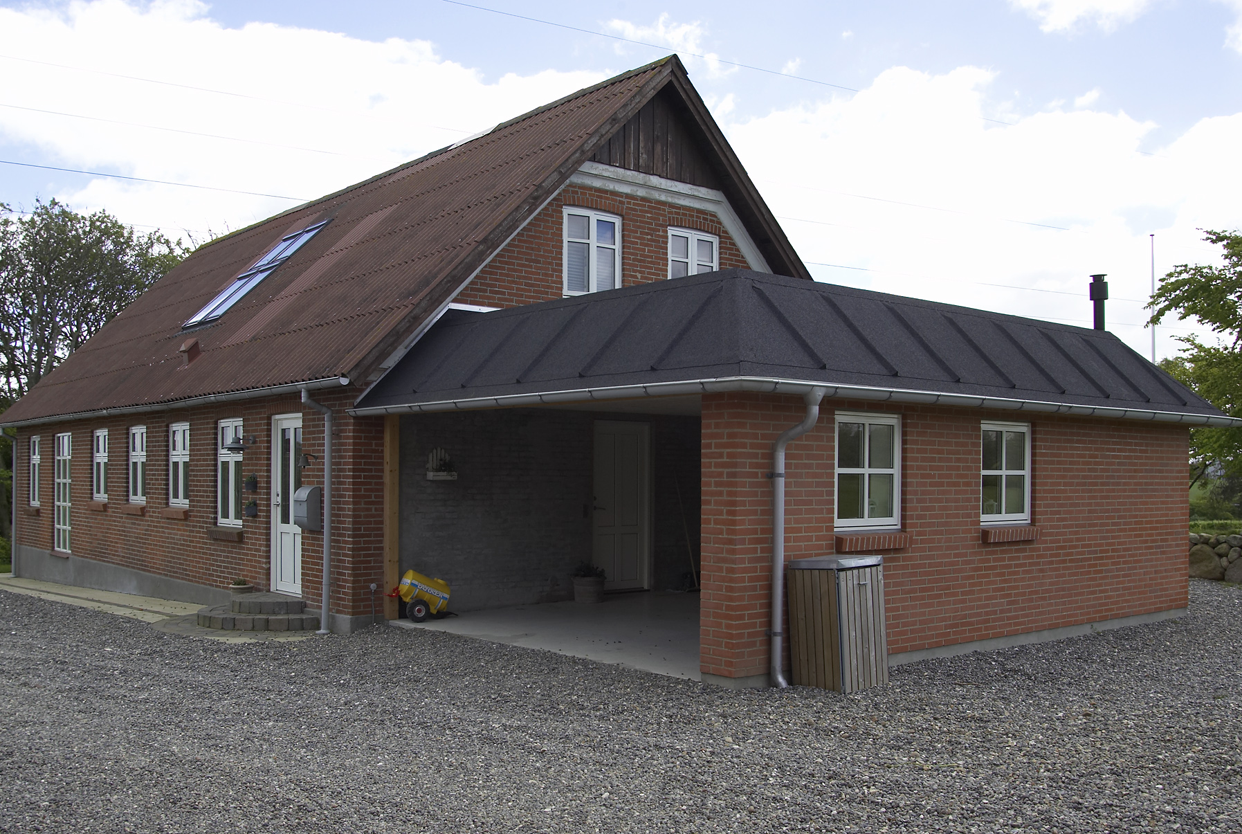 Rødstenshus med carport og grusindkørsel
