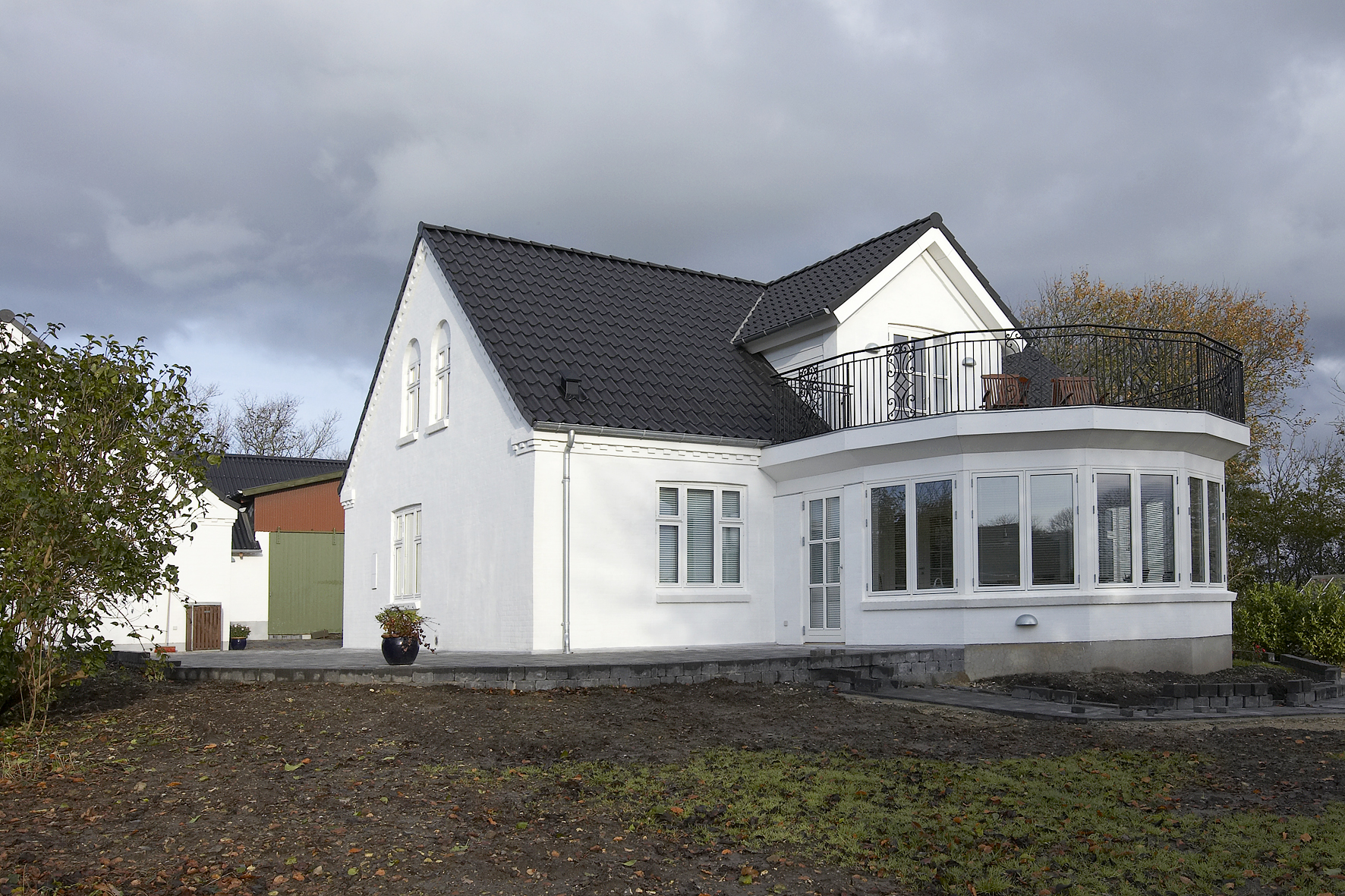 Hvid villa med sort tag og altan