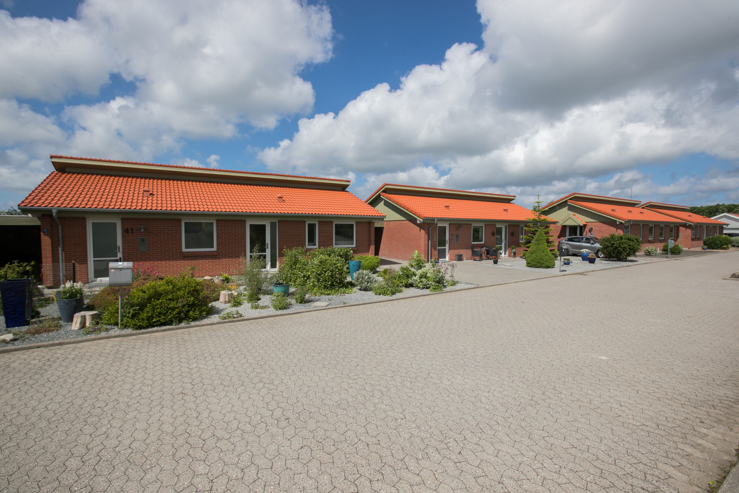 Rækkehuse med røde tegltage på stille villavej